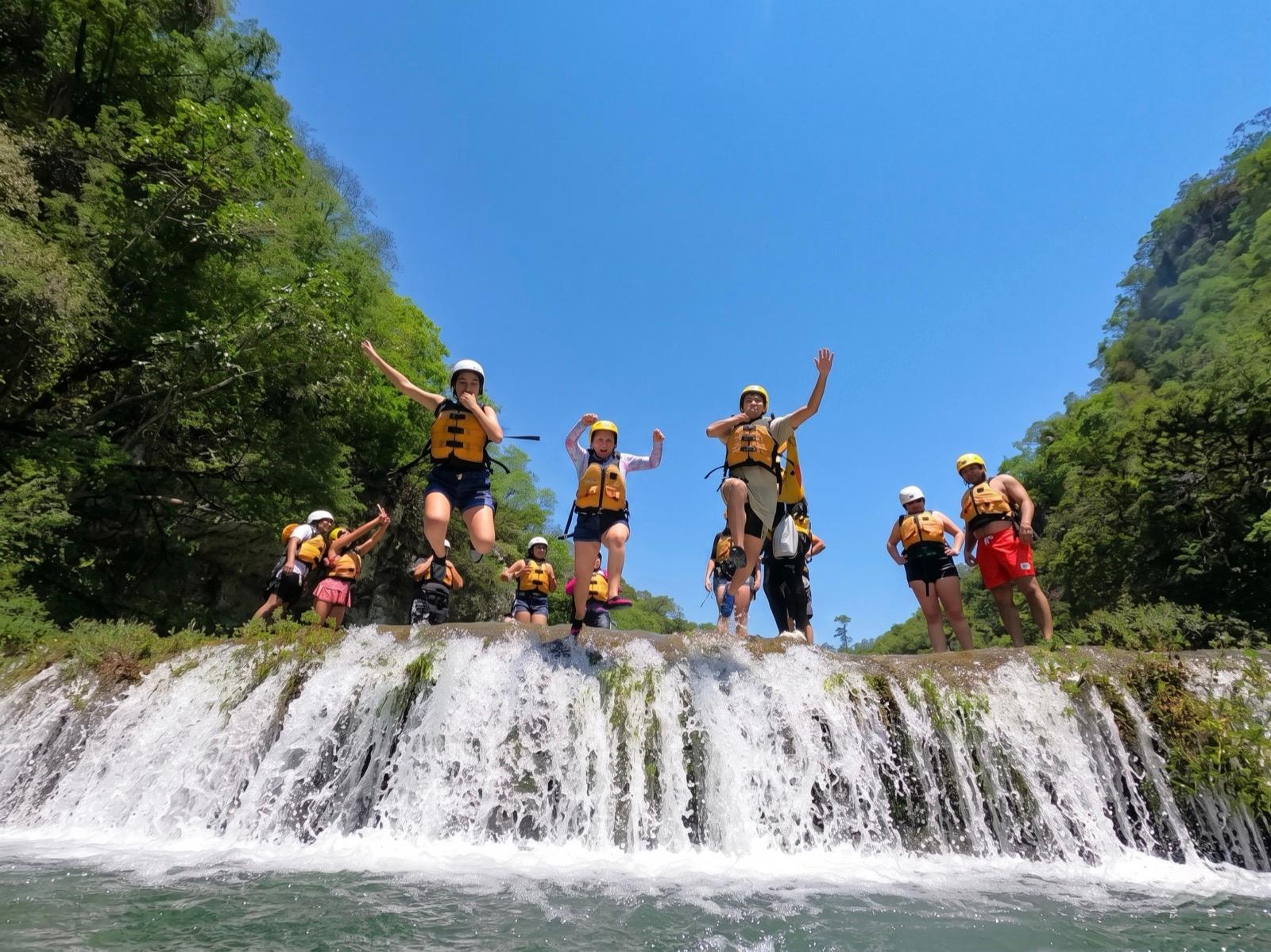 Grupo saltando en familia desde las cascadas de Micos — diversión para todos