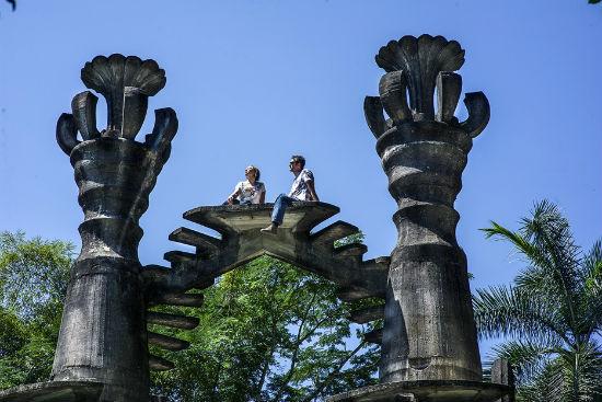 Dos visitantes sentados en lo alto de una estructura del jardín, sin nadie más alrededor