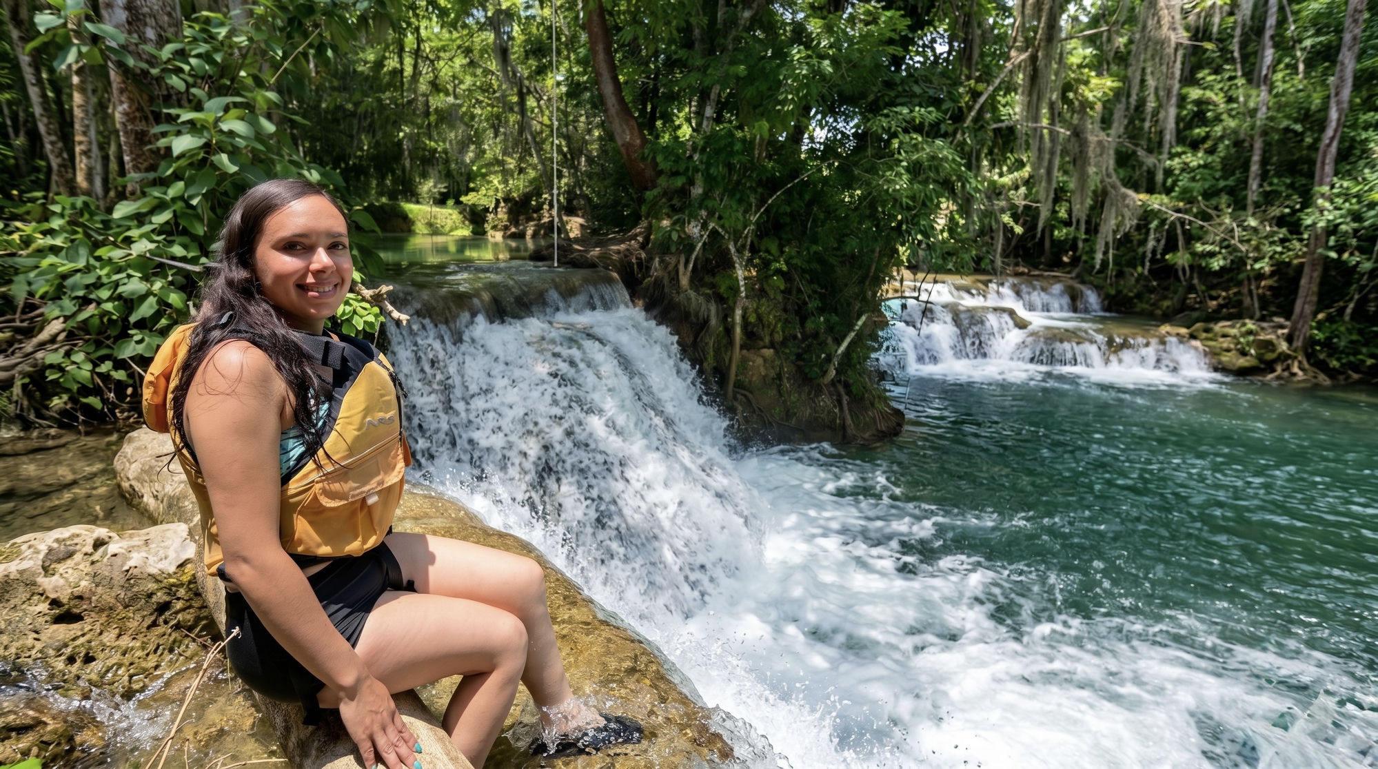 Turista de pie observando la cascada del Puente de Dios desde las rocas del cañón