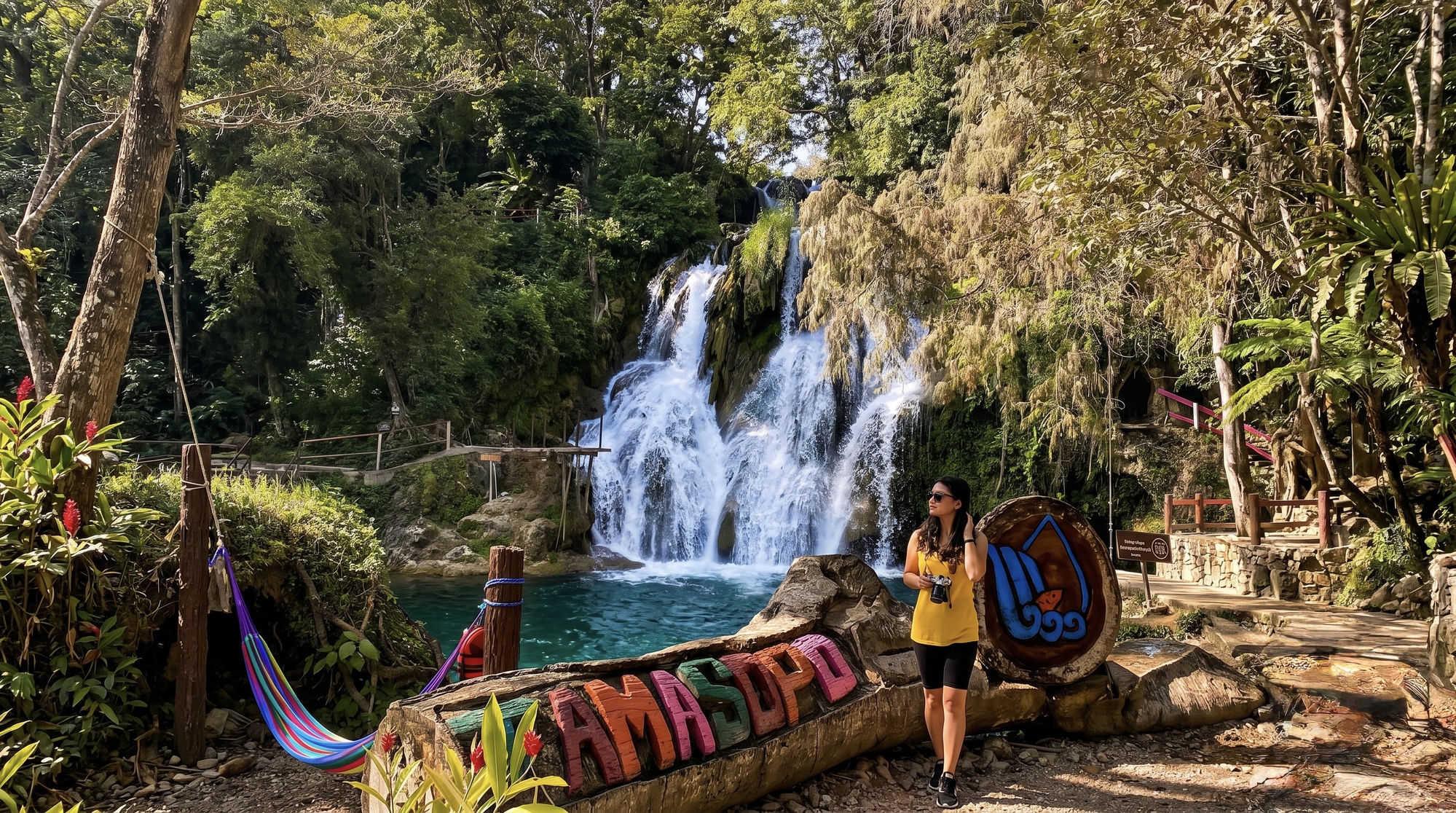 Mujer sonriendo con chaleco en la Hacienda Los Gómez con cascada de fondo
