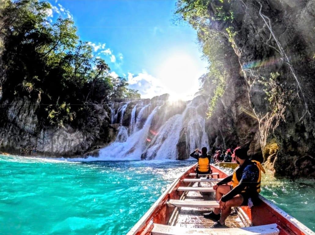 Cascada del Meco — canoa acercándose a la caída con el sol de frente