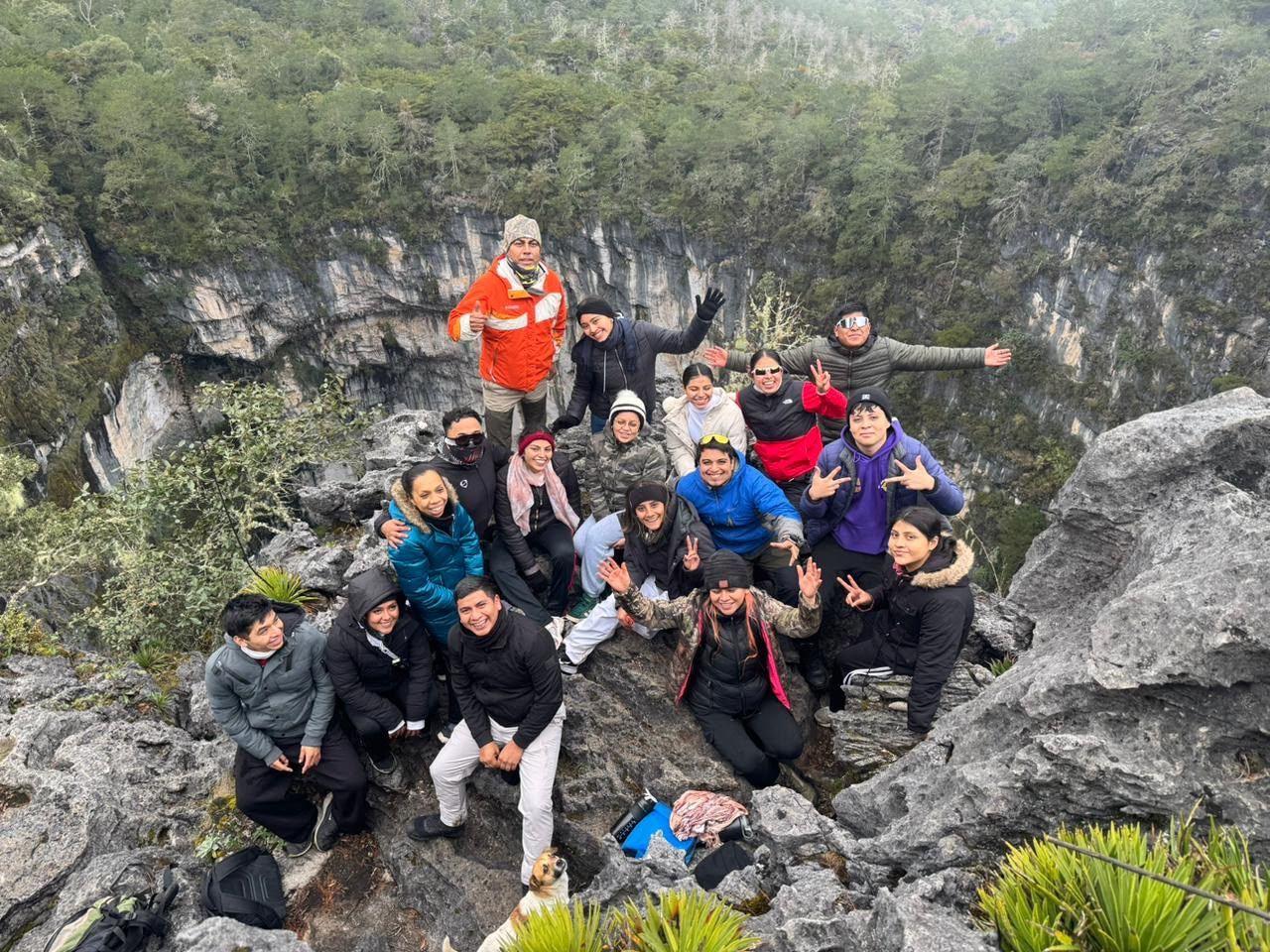 The whole group posing on the rocks at the rim of Olla de la Luz at the end of the walk