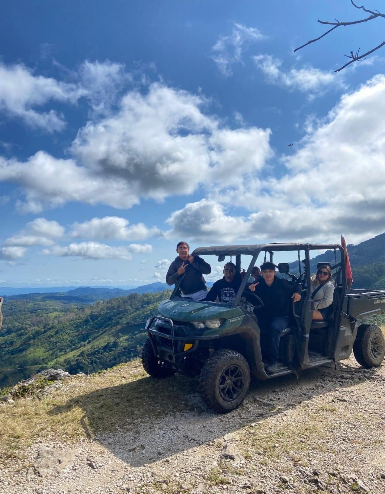 Mirador de la sierra — una familia en su Defender bajo el cielo azul