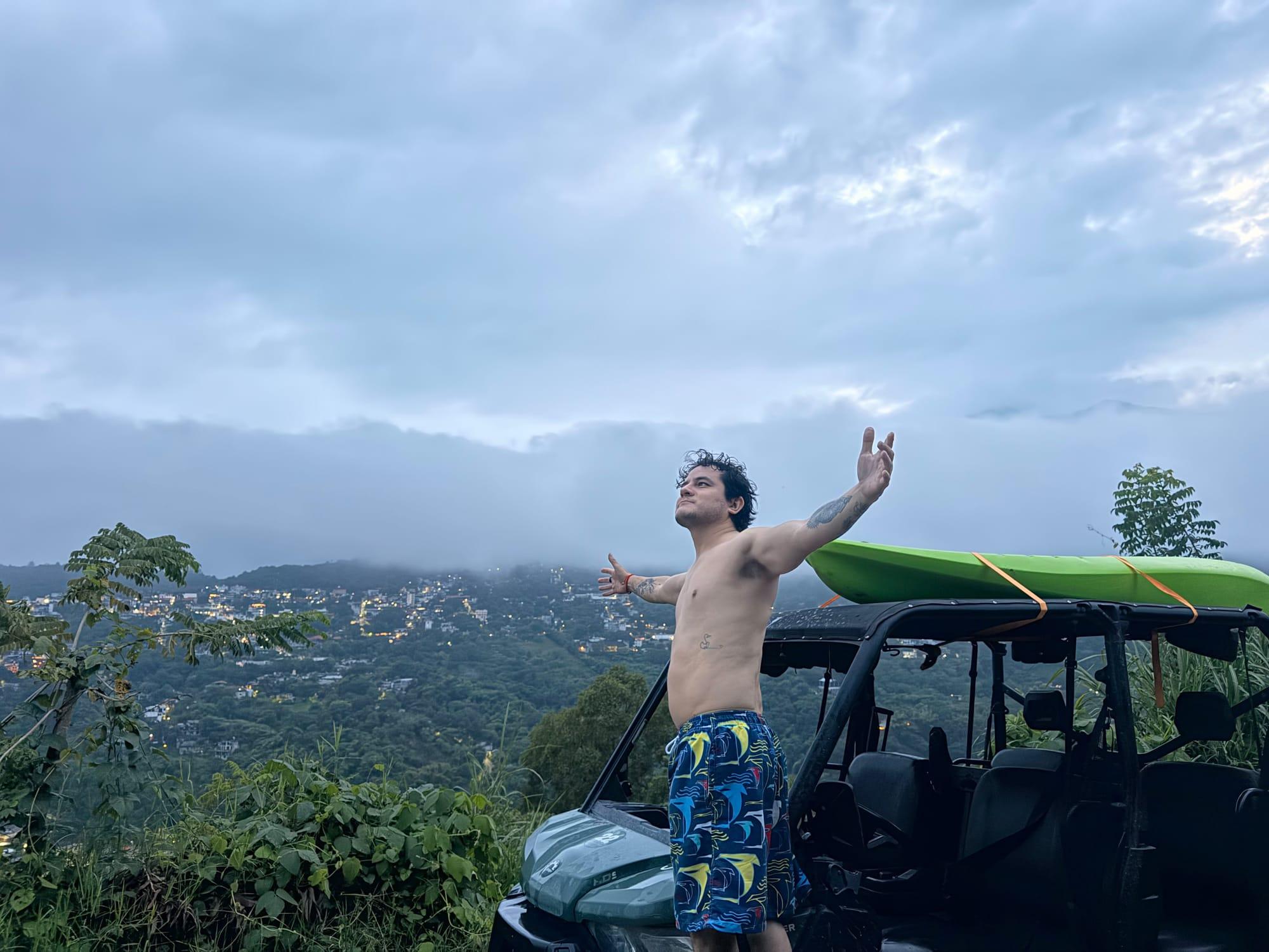 Mirador sobre Xilitla — brazos abiertos frente al pueblo iluminado al anochecer