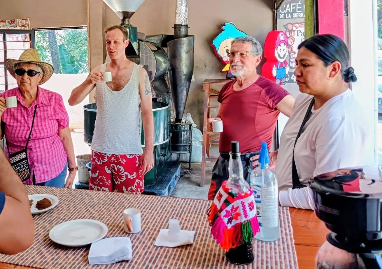 Group of visitors tasting freshly poured coffee next to the roaster at the Xilitla coffee farm