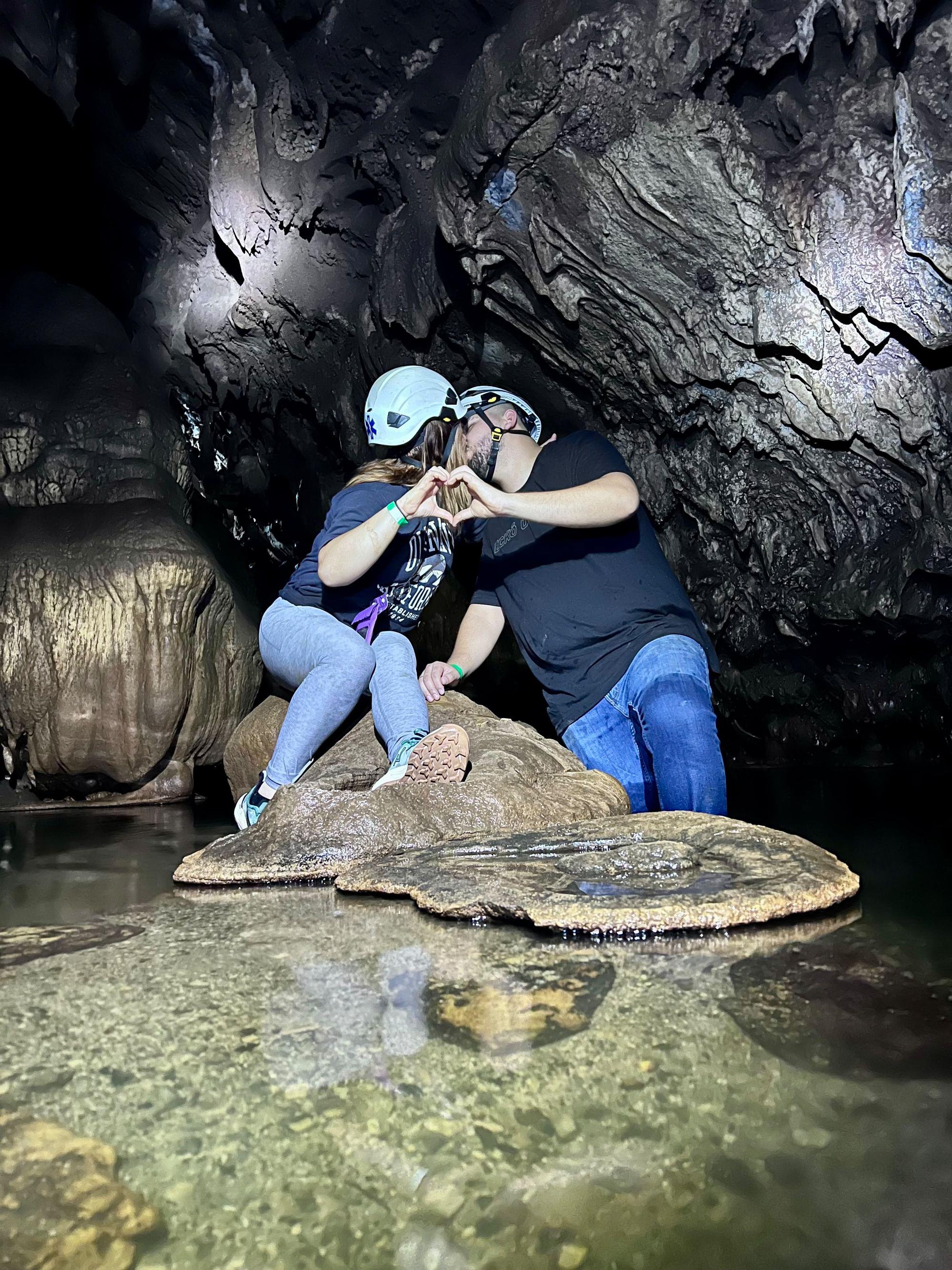 Pareja sobre una roca en uno de los jacuzzis naturales de agua cristalina del final del recorrido