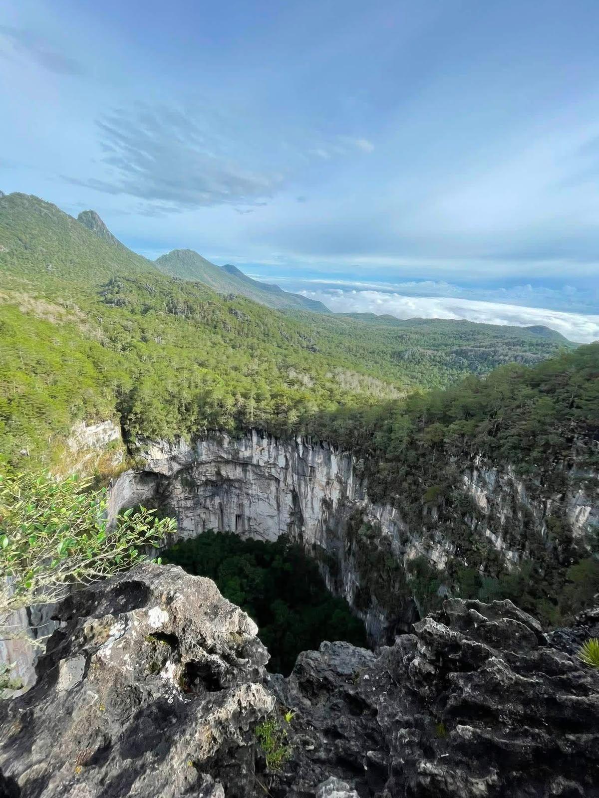 La boca de la Olla de la Luz desde el mirador, con la sierra y el mar de nubes al fondo