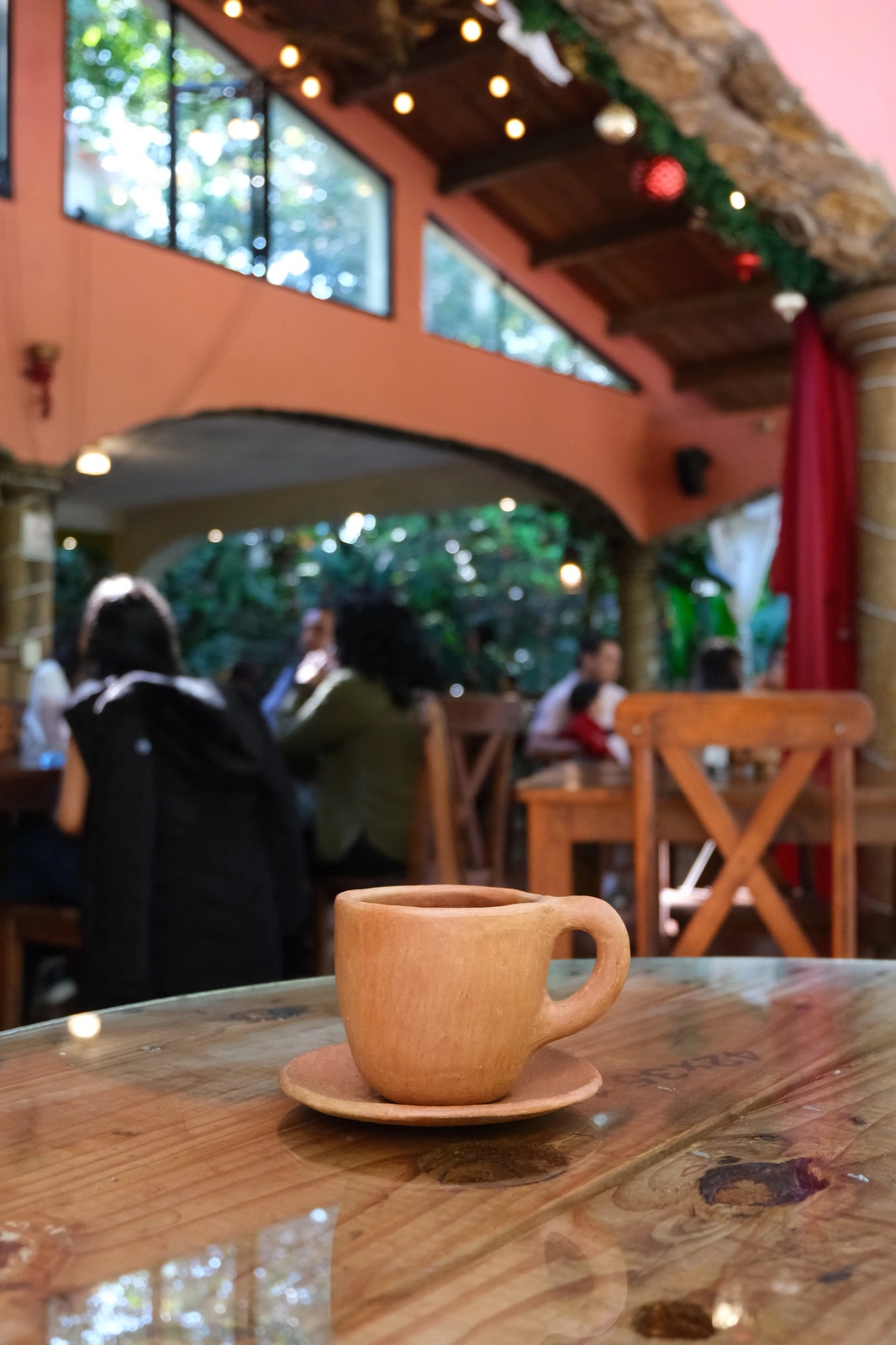 Taza de café de barro sobre la mesa del restaurante Papán Huasteco en Xilitla, con vista a la selva