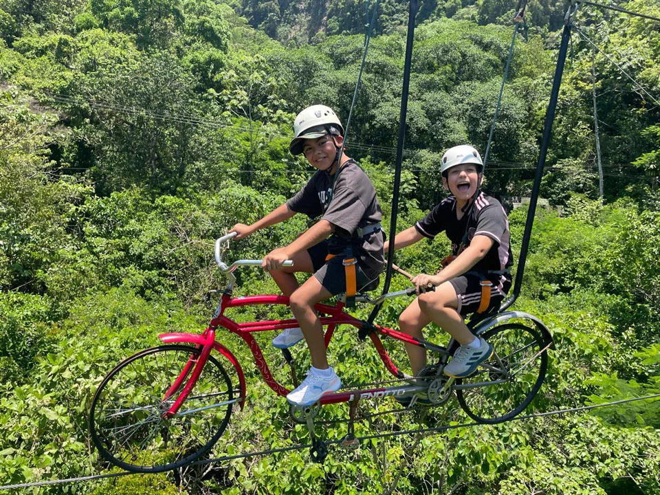 Niños pedaleando en bicicleta aérea sobre la selva en Cascadas de Micos — actividades para niños en Xilitla