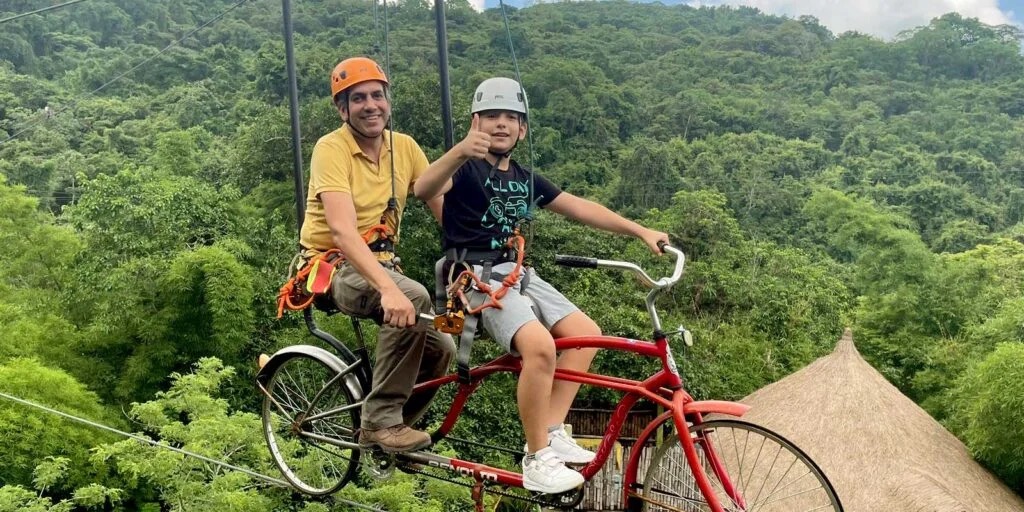 Niños pedaleando en bicicleta aérea sobre la selva en Cascadas de Micos — actividades para niños en Xilitla
